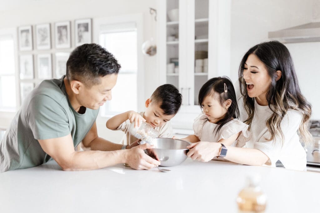 Family sitting together at the kitchen island enjoying a baking activity