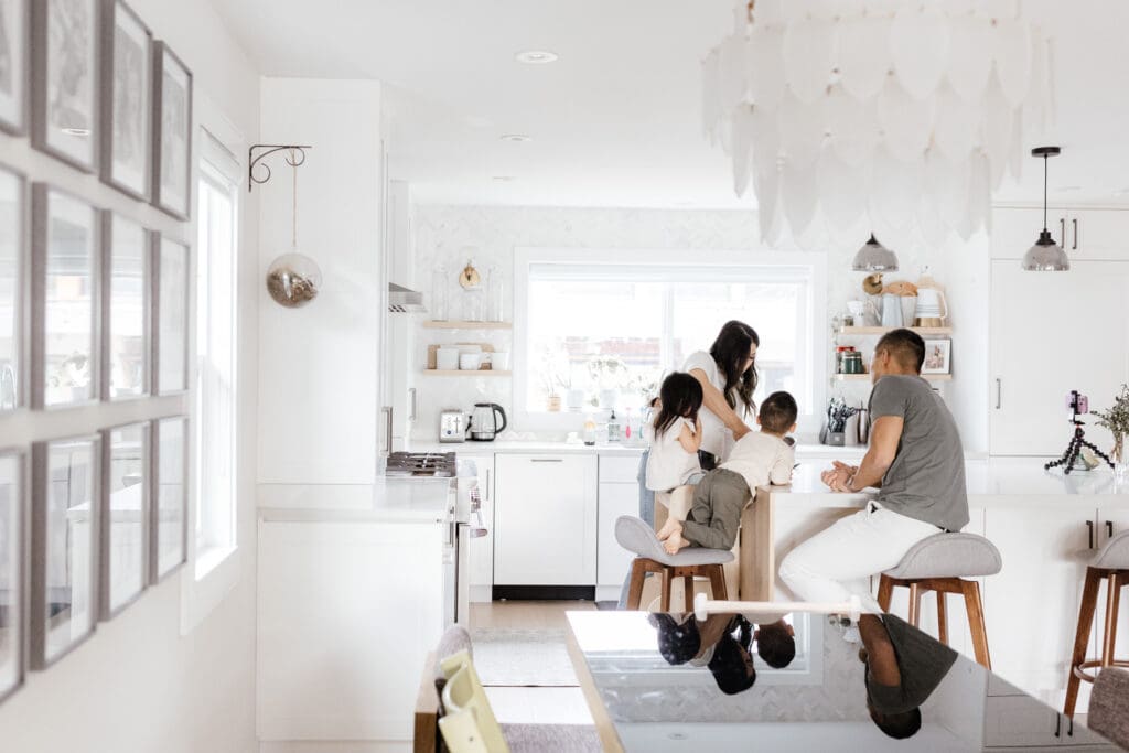 Family gathered around the kitchen island preparing food together.