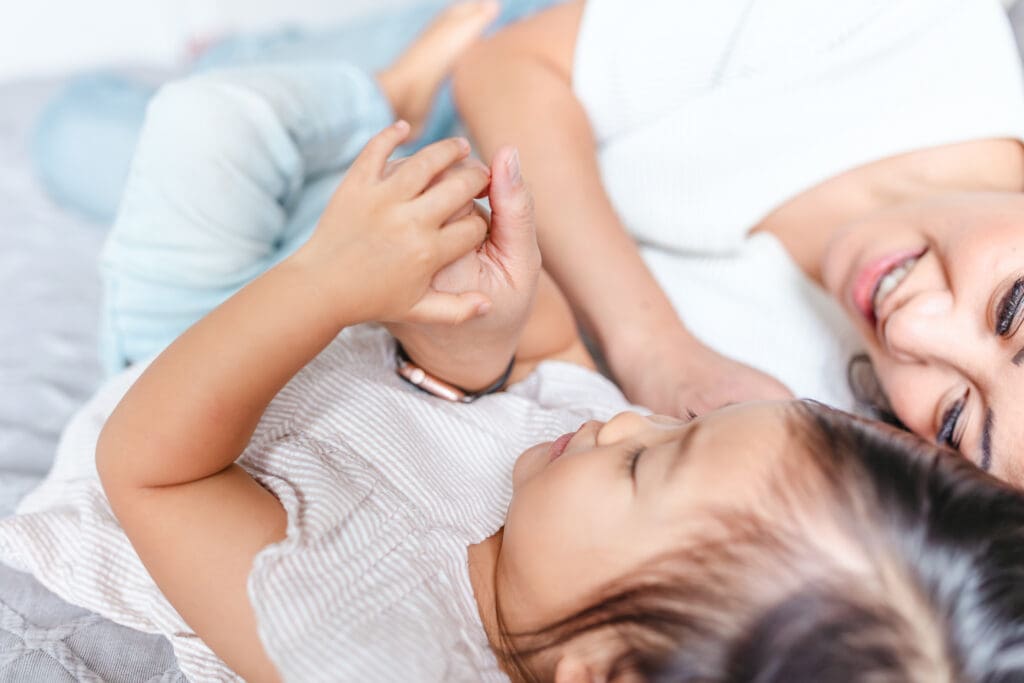 Close-up of a child’s small hand resting gently on their parent’s hand.