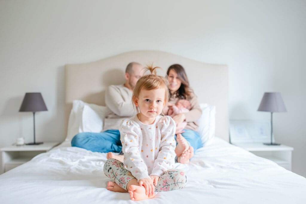 Family wearing coordinated neutral outfits during an in-home newborn family photography session near Vancouver