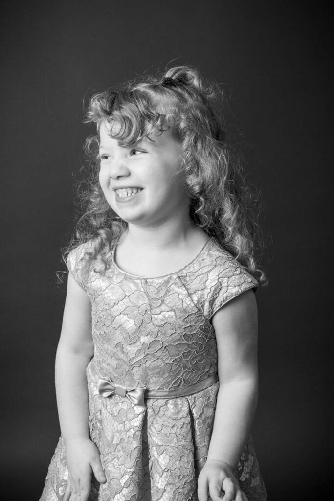 Classic black and white preschool portrait on dark backdrop during daycare photo day