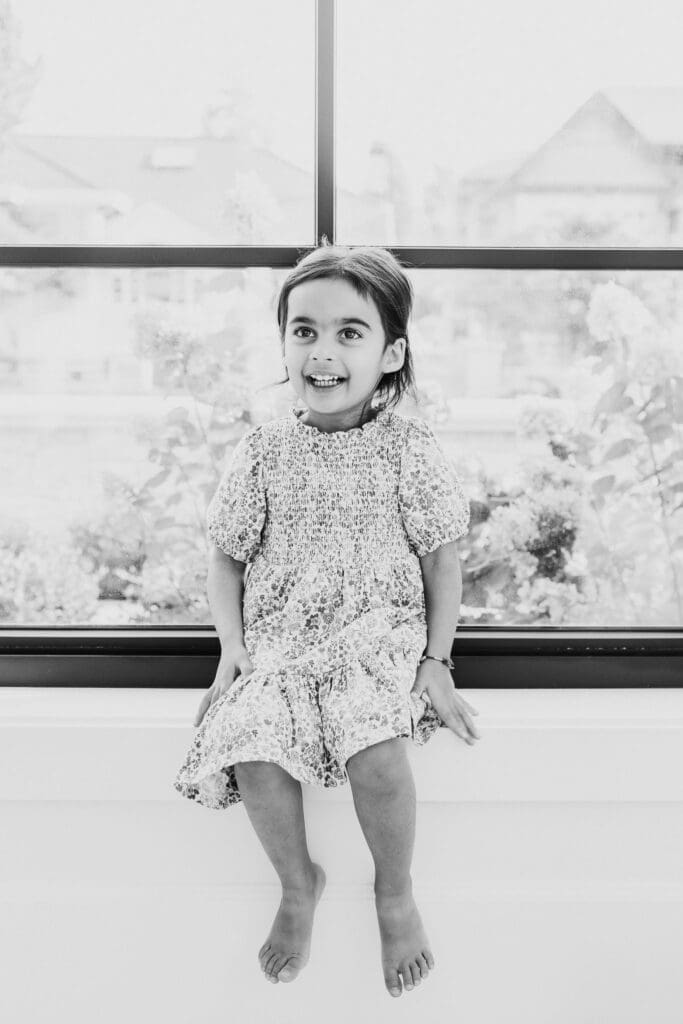 Young child playing by a window during an in-home family photography session in Vancouver.