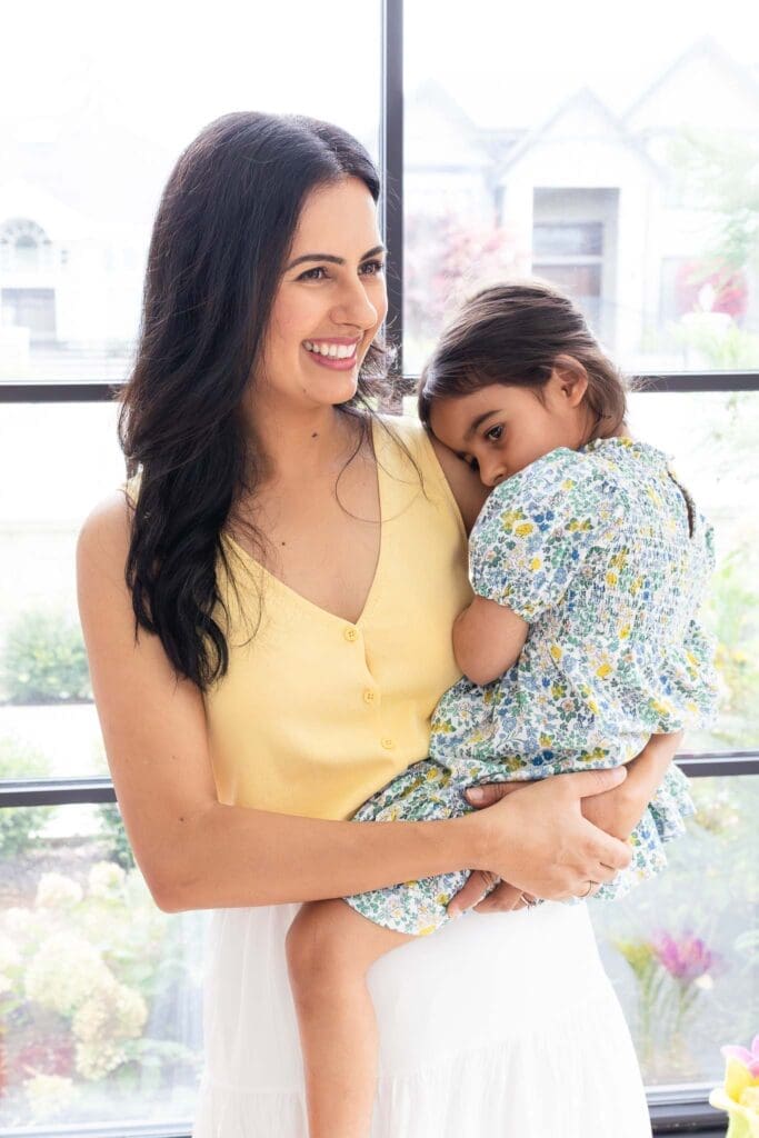 Mother holding her child near a window during an in-home family photography session in Vancouver.
