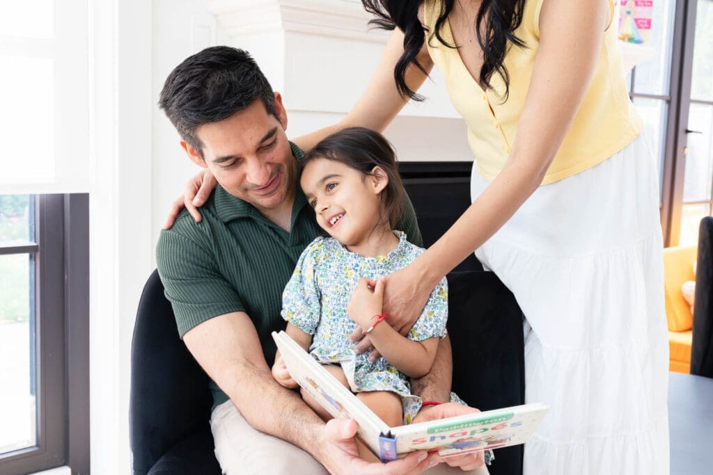 Father holding his child and reading to her during a relaxed in-home family photography session in Vancouver.
