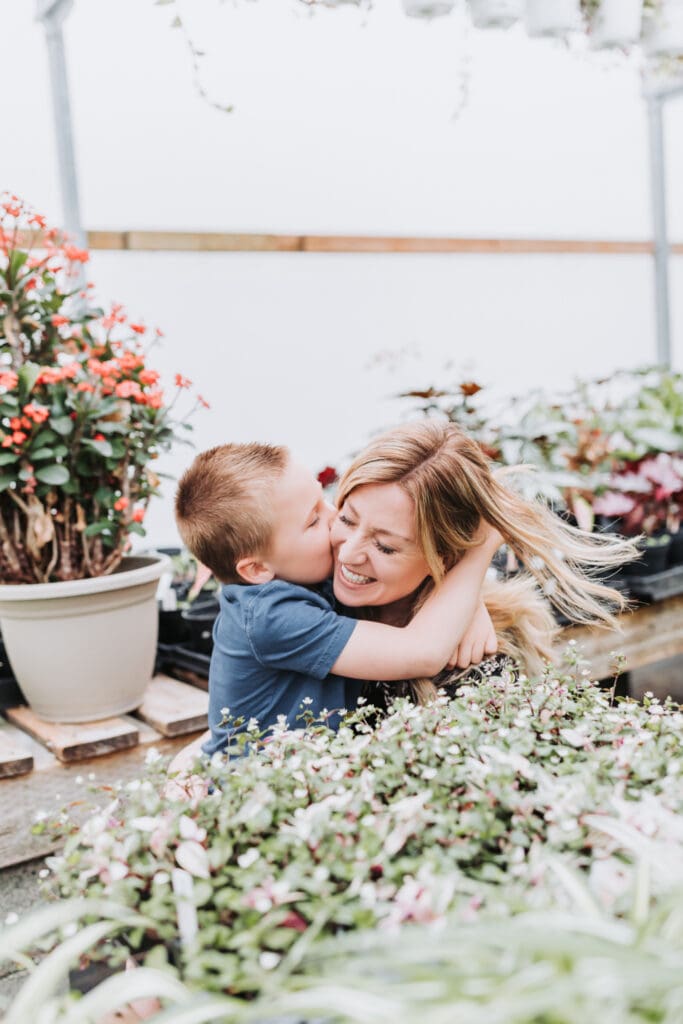 Light and airy natural family photos of mom and son captured in a greenhouse setting in Vancouver