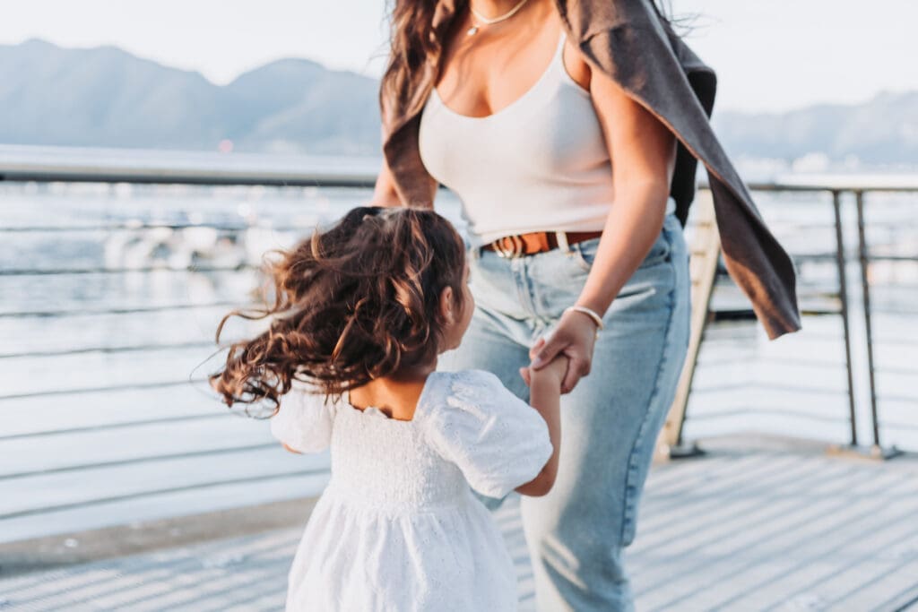 Mother and child in soft blue and beige outfits during family portraits in Coal Harbour, Vancouver