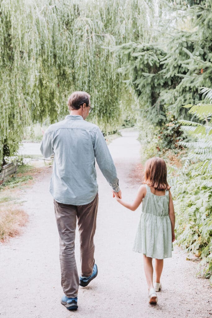 Father and daughter walking on trail at lost lagoon in vancouver