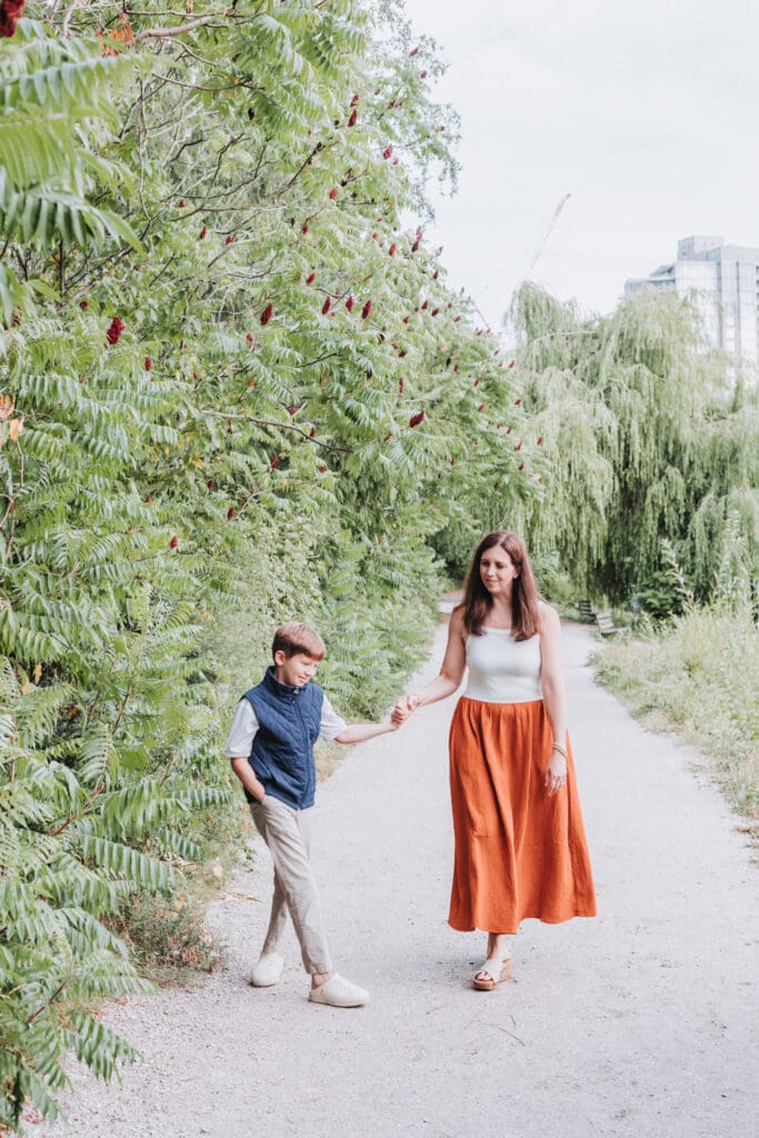 Mother and son walking on trail at lost lagoon in vancouver