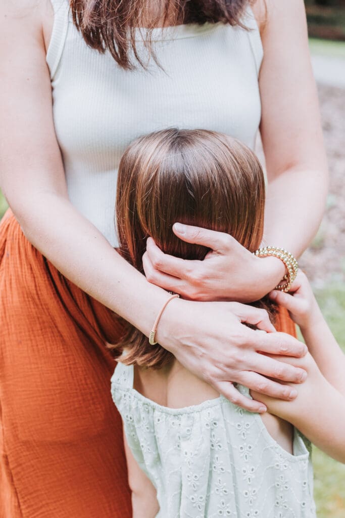 Parents cuddling with their children near Stanley Park Pavilion