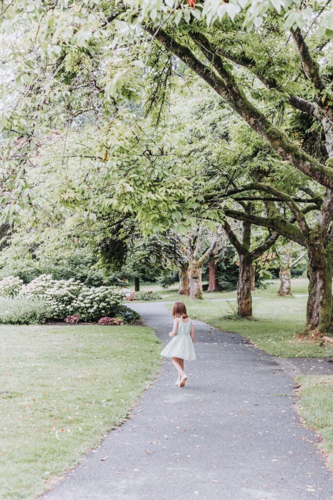 young girl running through the gardens in stanley park