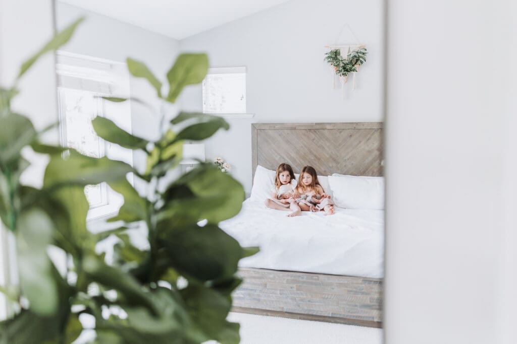 Toddlers cuddling newborn sibling during Surrey family photography session