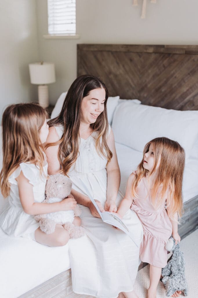 Mom reading with two toddlers during an in-home newborn session